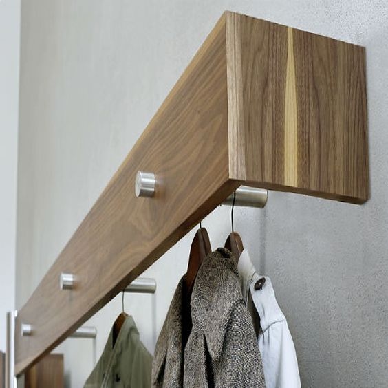to make the look more uncluttered and unified, choose such a rack with metal hooks and a wooden panel that covers them