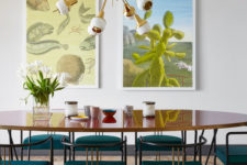04 The dining space features gorgeous teal chairs and a duo of mid-century posters