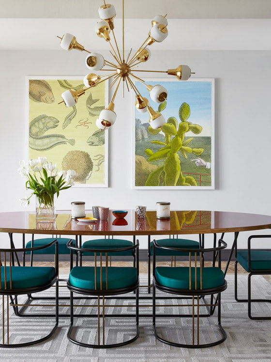 The dining space features gorgeous teal chairs and a duo of mid century posters