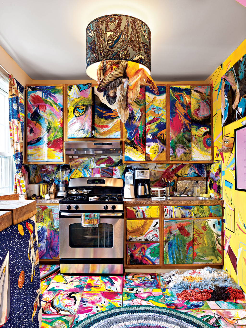 The kitchen looks like a crazy space, all painted bold colors in crazy combos with a waterolor effect
