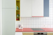 04 a minimalist color block kitchen with coral, aqua and blue accents and white tiles with black grout