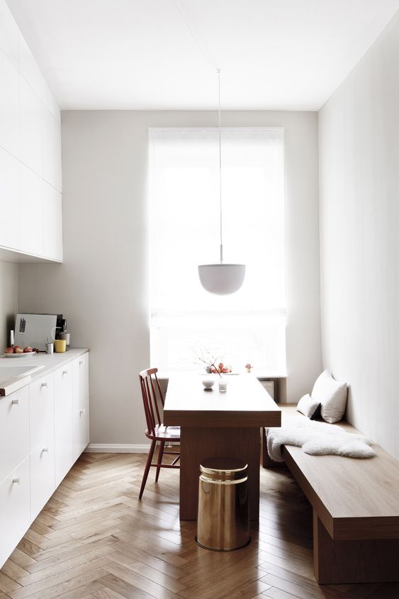 a minimalist space with a comfy bench and a dining table, which can be used as a kitchen island, too