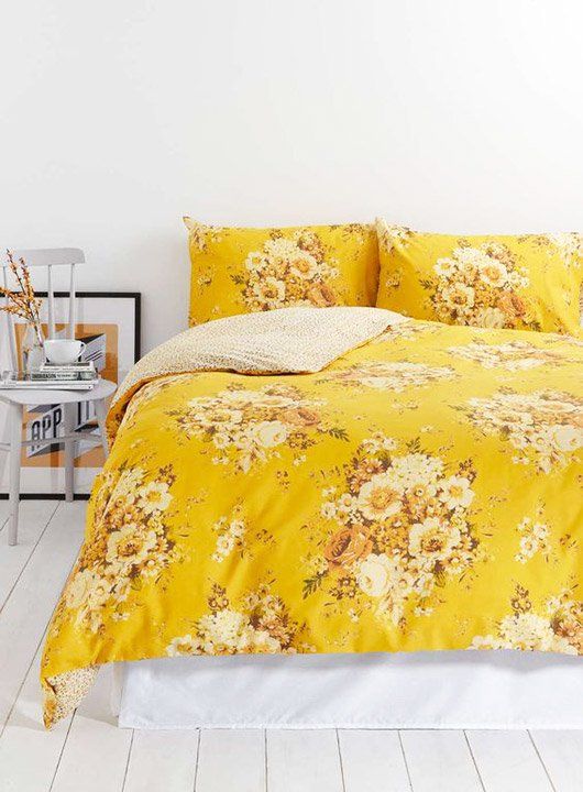 a neutral space with bold yellow floral print bedding for a romantic touch