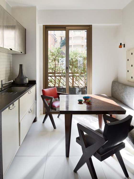 The kitchen is rather small and its main accent feture is sculptural chairs and a table plus an upholstered bench
