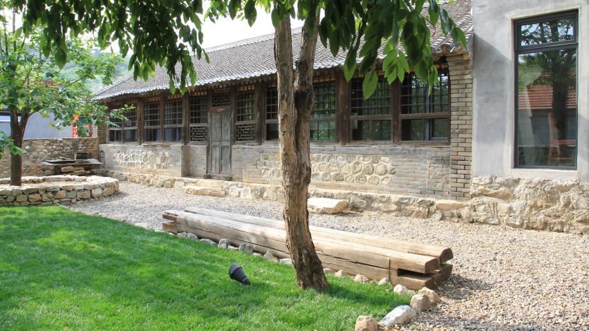 The outdoor spaces are styled with gravel and lawns, there's stone cladding and benches made of logs