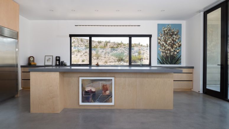 There's a large kitchen with a big kitchen island and cabinets plus desert views