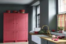 05 a grey kitchen with a large pink cabinet for a color block effect is a bold and trendy idea