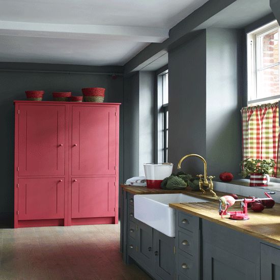 a grey kitchen with a large pink cabinet for a color block effect is a bold and trendy idea