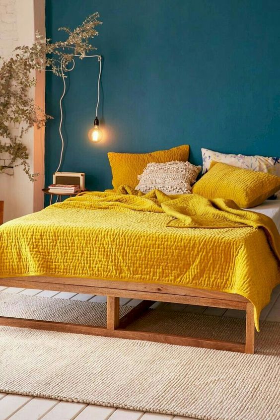 a teal wall and bright yellow bedding create a super bold contrast and a wow look