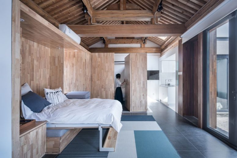 The bedroom is done with light-colored plywood and touches of blue and white for a fresh feeling