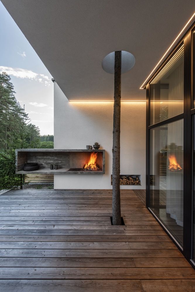 The deck features an open fireplace and a tree growing through the deck for more coziness