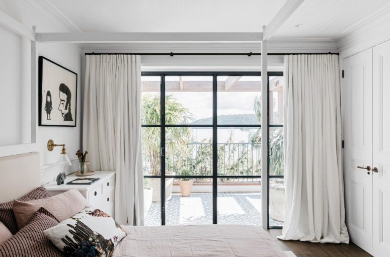 The master bedroom is fully opened to outdoors through a glazed wall with a door