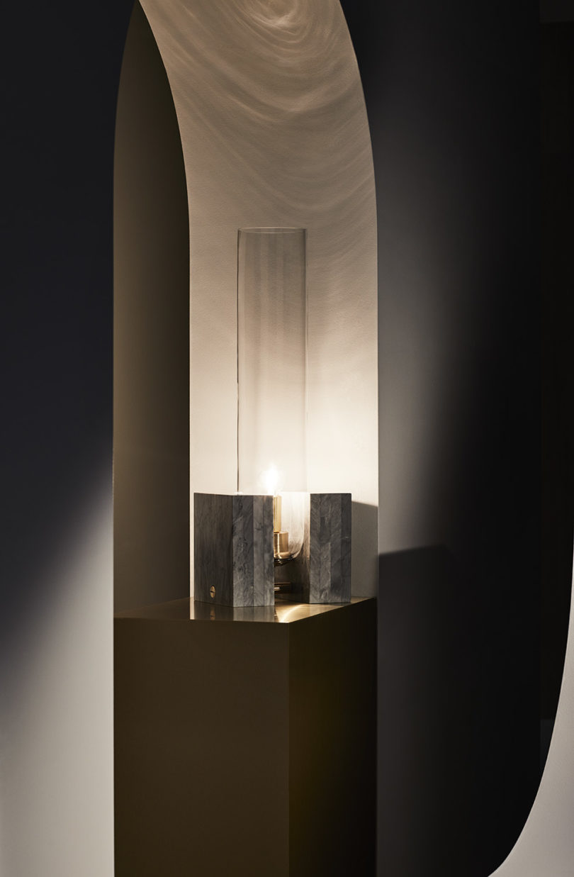 The pieces features a base and a large cylindrical lampshade of glass
