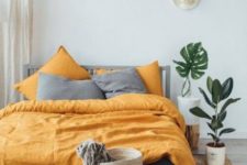 06 a boho bedroom with grey and yellow bedding that creates a contrasts and brings sunlight to the space