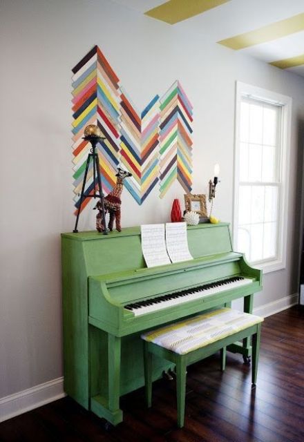 a grass green piano and a bold chevron artwork right on the wall to add color and interest to the space