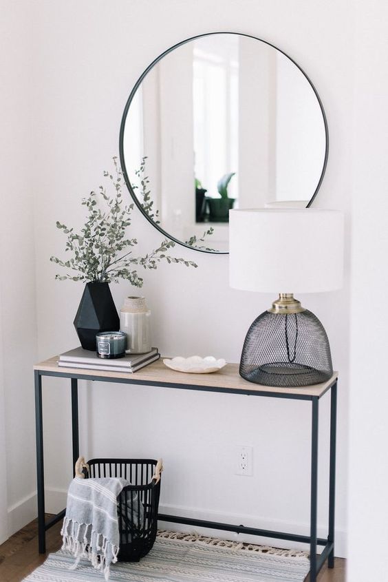 a round mirror in a modern grey frame is a chic and simple idea for a contemporary entryway