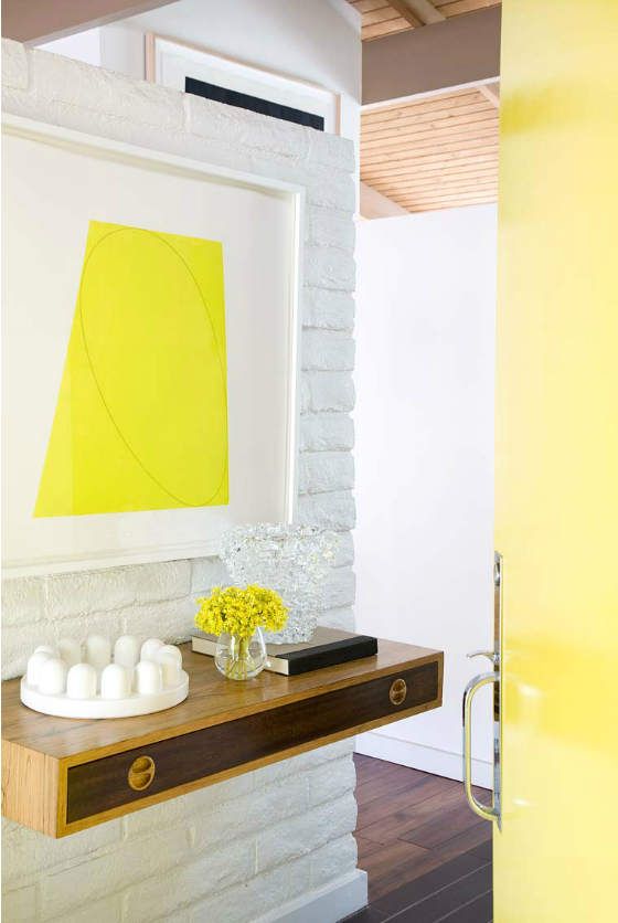a small floating plywood console with a drawer and a colorful artwork over it for a chic look