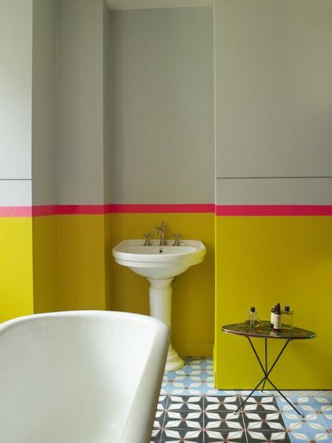 a sunny yellow and light green bathroom with a bold pink stripe looks really bold and unusual