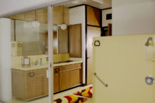 07 The master bathroom is very eye-catchy, with yellow tuiles and brown wooden furniture plus storage items