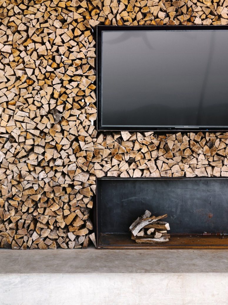 There's a whole firewood wall with a TV and a niche for a rustic feel