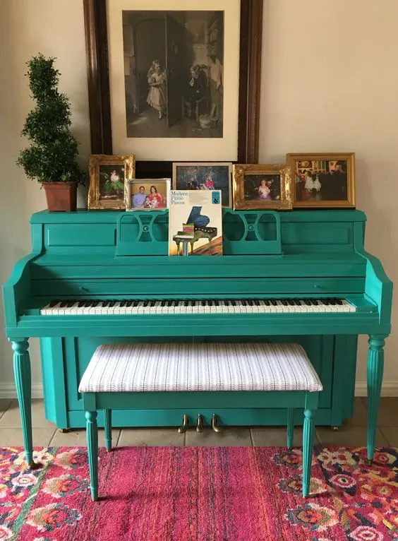 a bold turquoise piano and a matching stool with upholstery, family photos on display