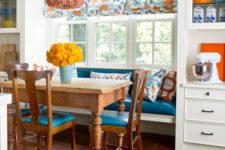 07 a colorful kitchen with a bold and bright eating space with a rustic dining set and an upholstered banquette