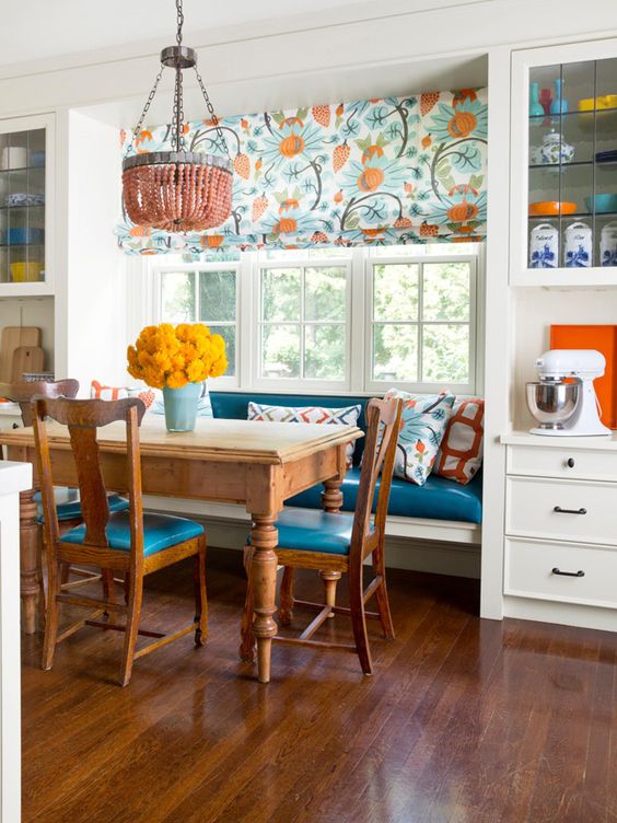 a colorful kitchen with a bold and bright eating space with a rustic dining set and an upholstered banquette