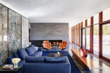 08 The living room is done with luxurious and colorful furniture and a built-in fireplace