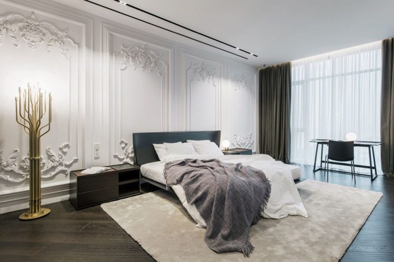 The master bedroom is done with moldings, modern furniture and touches of brass for a glam feel