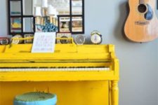 08 a bright yellow piano and a colorful stool, a framed mirror and a display of vintage clocks on the piano
