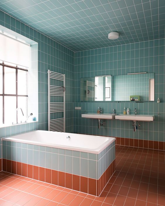 a light blue and rust bathroom fulled clad with tiles and diluted with whites here and there