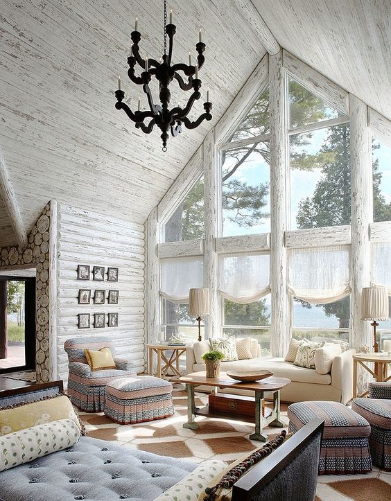 A rustic space with an attic roof is highlighted with whitewashed wood walls and ceiling plus frames of the windows