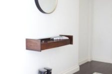 08 a tiny floating dark-stained wood console and a mirror in a metallic frame for a chic look