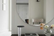 08 an oversized round mirror with no frame is a bold and modern statement for your entryway
