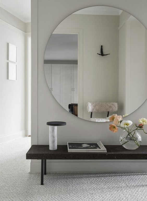 an oversized round mirror with no frame is a bold and modern statement for your entryway
