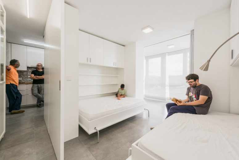 The bedroom area features two fold-down wall beds which frame the large windows