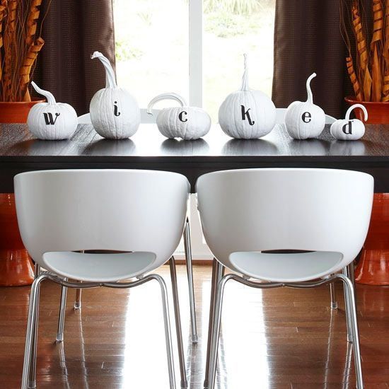 a minimalist pumpkin display in black and white instead of a usual table centerpiece is a cool idea