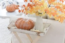 09 a vintage fall display with a little table filled with pumpkins and fall branches with leaves in a vase