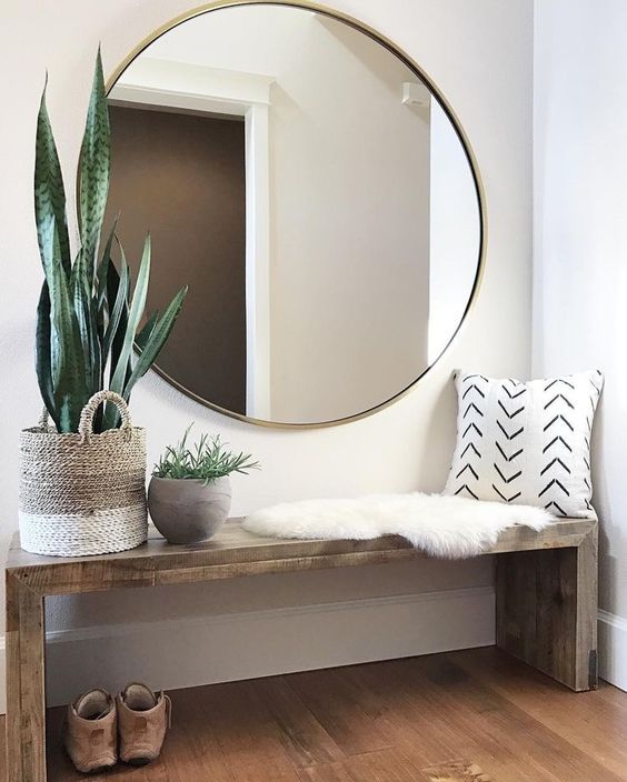an oversized round mirror in a brass frame is a cool modern idea suitable for boho or contemporary spaces