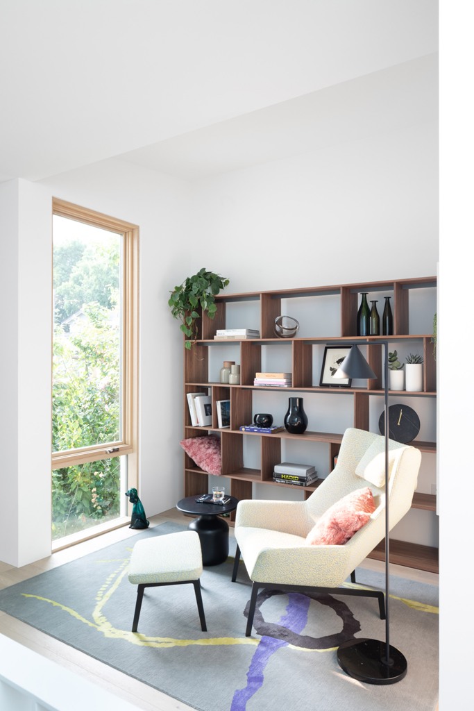 Comfy furniture is everywhere, here's a reading nook with a chair and a footrest plus a large storage unit