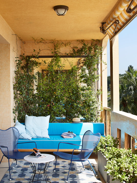 This is another side of the balcony, which is a comfy breakfast nook with a bright sofa