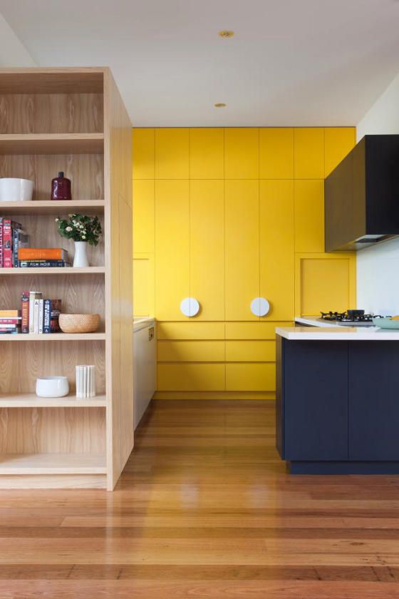 a chic contemporary kitchen in navy and sunny yellow with sleekdesign and white touches
