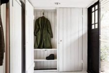 10 a cozy and simple entryway with whitewashed wood plank walls, ceiling and storage furniture