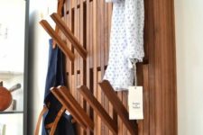 10 a creative wall-mounted clothes rack with wooden sticks that can be pulled out when needed and then hidden again