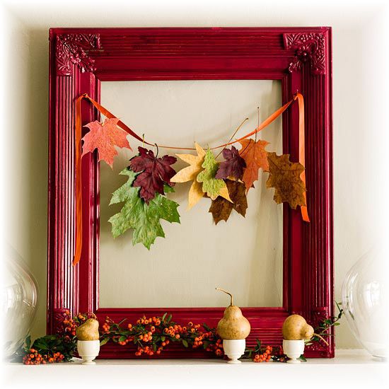 a cute and bold fall display with a red frame, a fall leaf garland and pears on egg stands