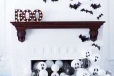 10 a modern Halloween mantel with marquee letters, bats and lots of black and white balloons in the fireplace