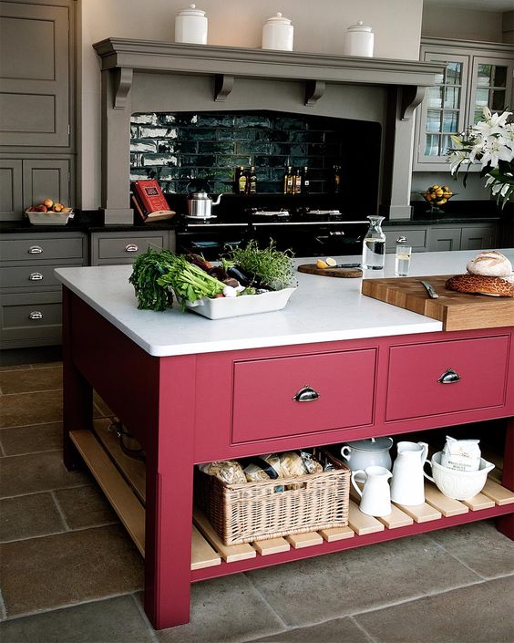 a color block effect is achieved in this grey kitchen with a bright pink kitchen island with a white countertop