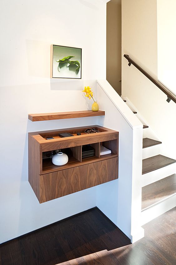 a contemporary plywood floating console with a sunken tabletop and a small shelf over the console