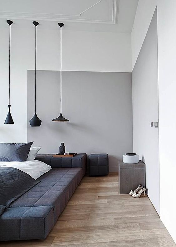 a grey element and a black upholstered podium bed for an edgy color block bedroom look