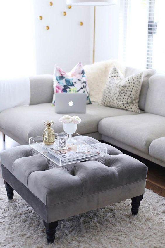 a grey upholstered ottoman doubles as a cool coffee table